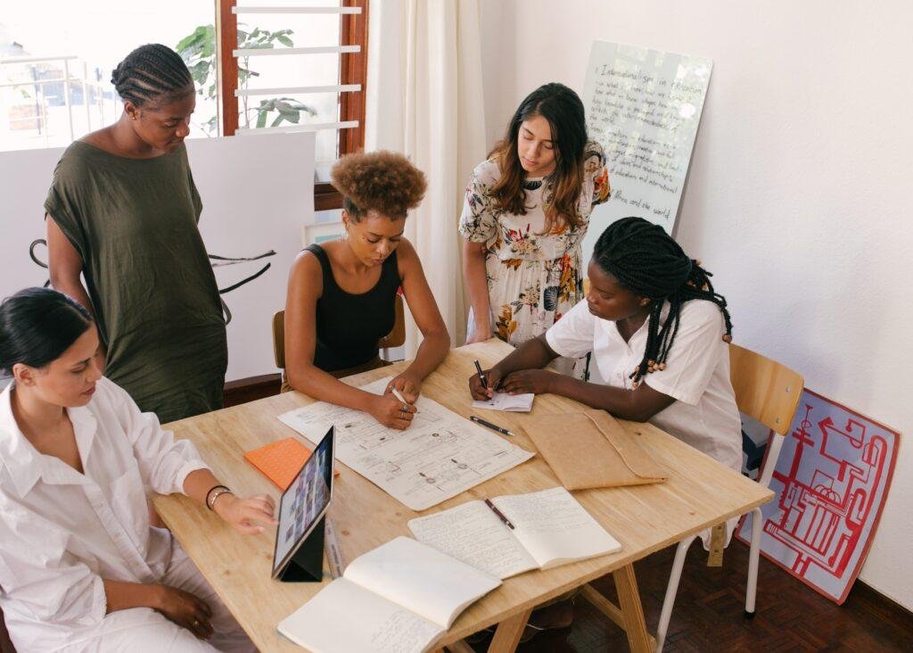 five women sitting down in a meeting room