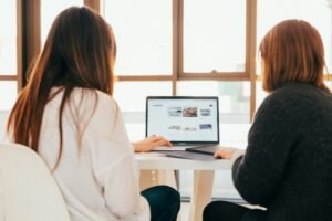 A business owner with a web designer Comparing WordPress, Joomla, and Drupal CMS platforms